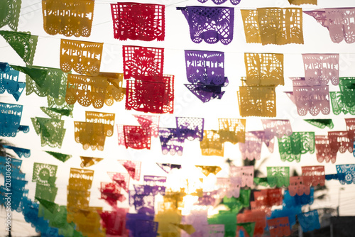 The name of the beach town Zipolite on banners of brightly colored papel picado (perforated paper), a traditional Mexican decorative craft, against morning sunrise, in Oaxaca, Mexico.