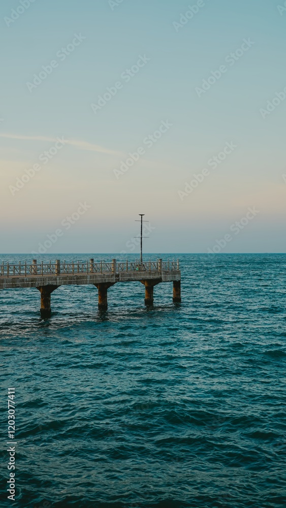 A bridge that stretches out over the sea, offering a view of the sunset in the evening.View of Bangsaen Beach, Chonburi Thailand. A bridge that stretches out over the sea, offering a view of the sunset in the evening.View of Bangsaen Beach, Chonburi Thailand.