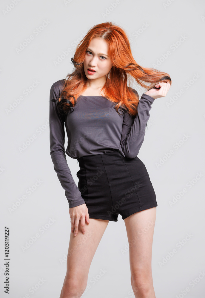 Half-body fashion beauty portrait of asian beautiful sexy cheerful confident young woman with long orange or red hair, model wearing long-sleeved shirt, black shorts posing looking on white background
