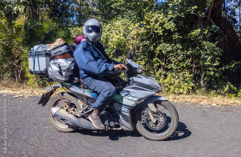 Obraz premium Man riding a motorcycle with luggage