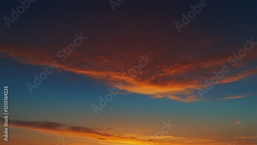 Obraz na płótnie Sunset in the sky . A photo of an orange cloud formation during sunset . The sky transitions from dark blue to orange as the sun sets. w salonie