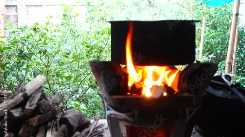 In a simple and old-fashioned way, cooking food with a stainless steel pot and an Anglo charcoal stove. to get a dark sooty color over a long time. The charcoal stove has a red light on it.
