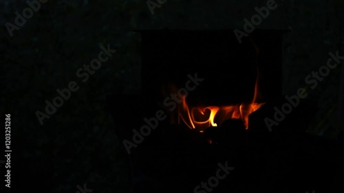 In a simple and old-fashioned way, cooking food with a stainless steel pot and an Anglo charcoal stove. to get a dark sooty color over a long time. The charcoal stove has a red light on it.