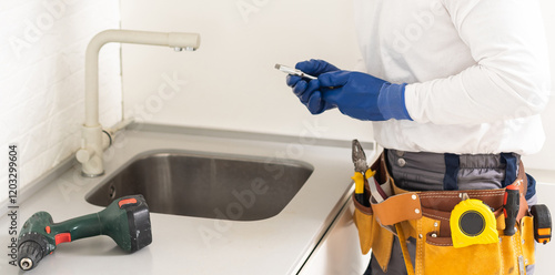 Male Plumber In Overall Fixing Sink photo