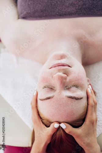 A girl in a pink uniform gives a massage to a woman. Back exercises, spa treatments