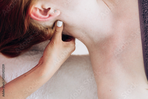 A girl in a pink uniform gives a massage to a woman. Back exercises, spa treatments