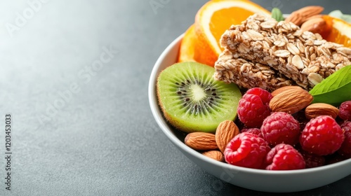 A delicious mix of fresh fruits, granola bars, and almonds arranged appealingly in a bowl, promoting a healthy lifestyle and wholesome eating habits. photo