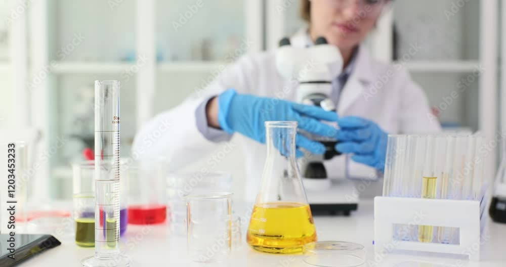 Scientist places glass slide with sample under microscope. Laboratory assistant observes microscopic structures of specimen. Slow motion Scientist places glass slide with sample under microscope. Laboratory assistant observes microscopic structures of specimen. Slow motion