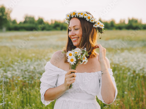 beautiful girl walks in a flower field at sunset in the summer of the country photo