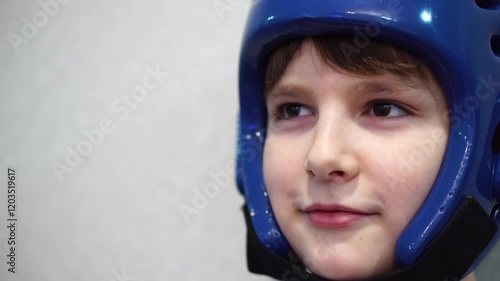 boy in taekwondo helmet with slight smile on face. close-up portrait