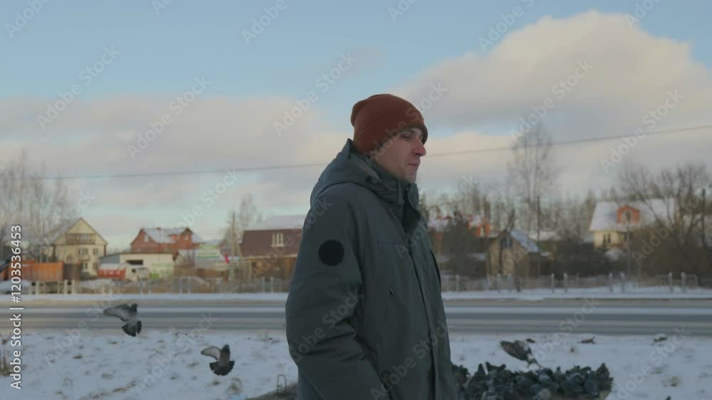 A man stands confidently against a cold urban backdrop, wearing warm attire snow-covered ground and modern buildings. A man stands confidently against a cold urban backdrop, wearing warm attire snow-covered ground and modern buildings.