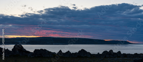 Moody summer evening with the light of the setting sun hitting a cloud. Båtsfjord, Varanger Peninsula, Norway photo