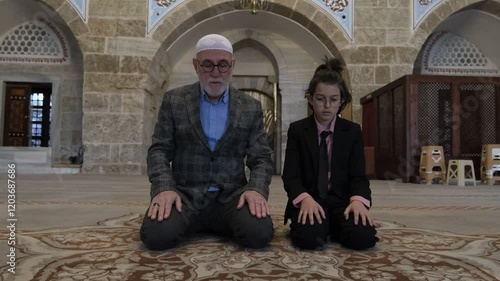 Grandfather and grandson perform salaat  photo