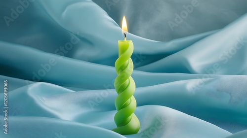 Spiral taper candle in green on light blue cloth background photo