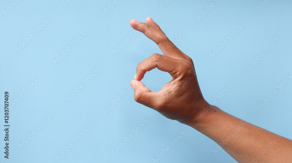 Close up of hand with gesture okay, Isolated on blue background, place for text or sign. Positive concept. Close up of hand with gesture okay, Isolated on blue background, place for text or sign. Positive concept.