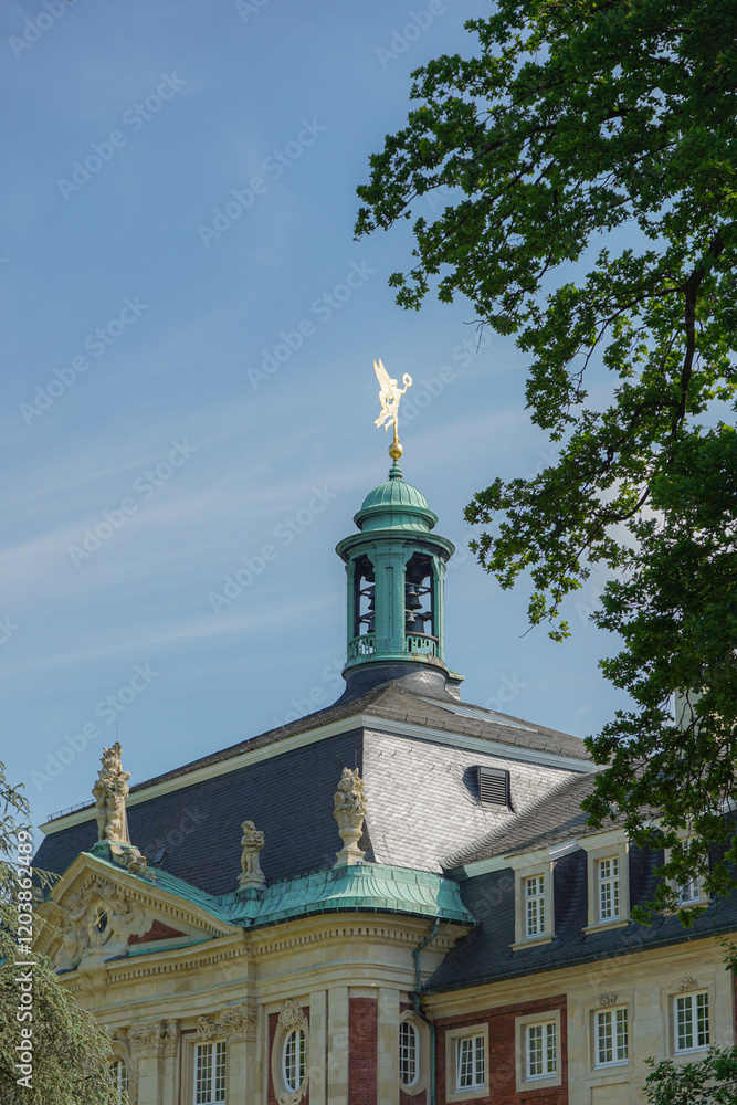 Top part green tower with gold detail of a University of Muenster building in elegant style, Münster, Germany Top part green tower with gold detail of a University of Muenster building in elegant style, Münster, Germany