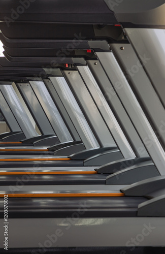 Perspective view of Treadmill at fitness center. Side view of Treadmill machines in the morning with sunlight, use it as your Wallpaper, Poster and Copy space, Selective focus.