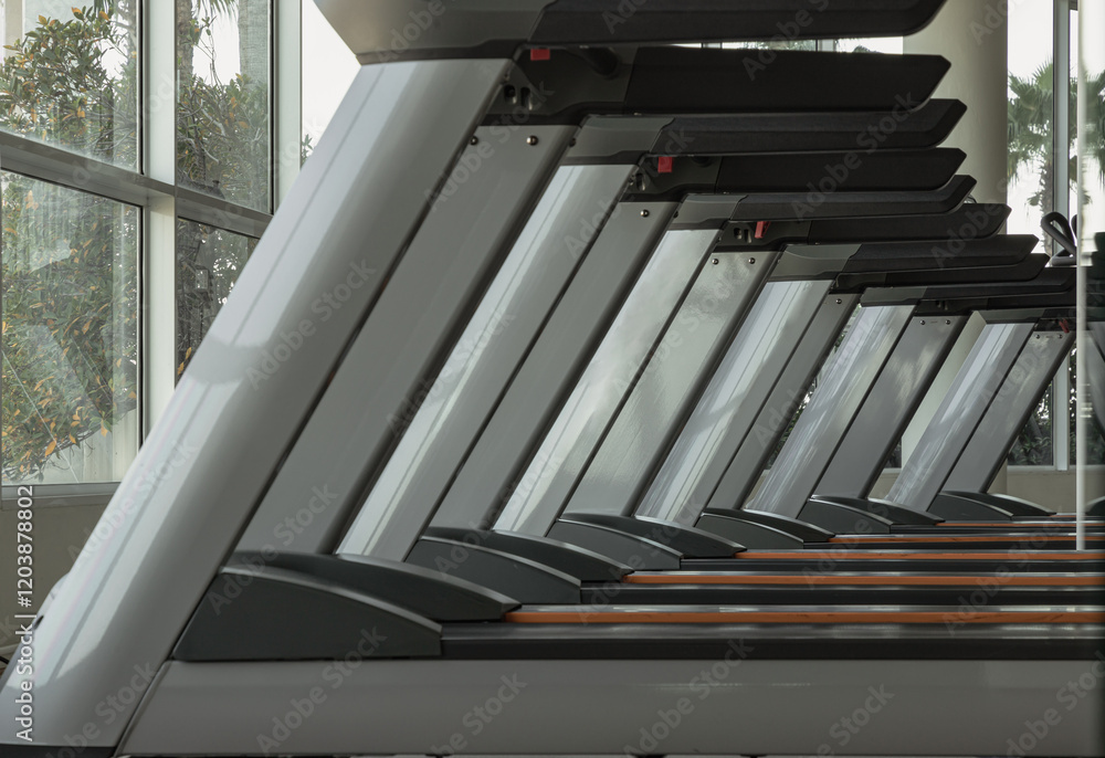 Side view of Treadmill in the morning with sunlight in fitness center. Perspective view of Treadmill machines, use it as your Wallpaper, Poster and Space for text, Selective focus.