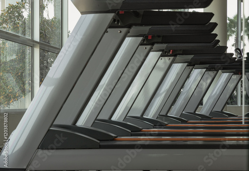 Obraz na płótnie Side view of Treadmill in the morning with sunlight in fitness center. Perspective view of Treadmill machines, use it as your Wallpaper, Poster and Space for text, Selective focus. w salonie