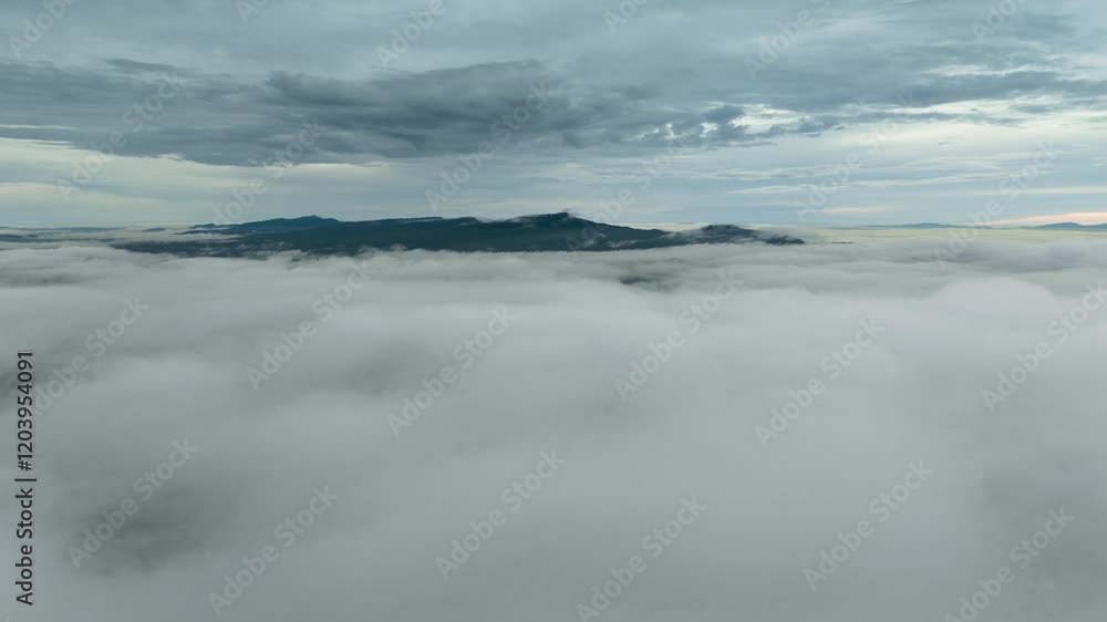 Aerial view of a beautiful landscape in northern Thailand, captured in a 4K hyperlapse video featuring white fog or clouds moving over the green forest below.
Aerial view of a beautiful landscape in northern Thailand, captured in a 4K hyperlapse video featuring white fog or clouds moving over the green forest below.