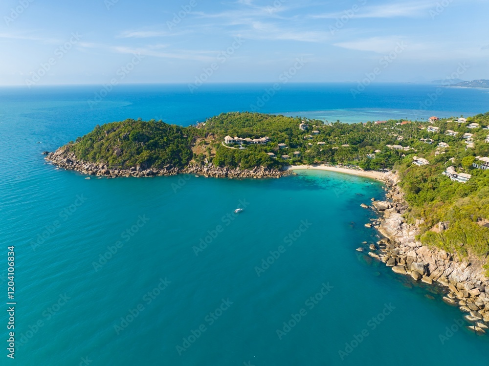Naklejka premium Coastal view from above showing turquoise waters and lush greenery on a tropical island