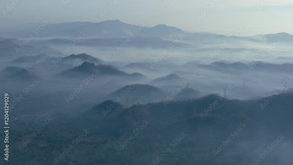 Aerial view of a beautiful landscape in northern Thailand, captured in a 4K hyperlapse video featuring white fog or clouds moving over the green forest below.
Aerial view of a beautiful landscape in northern Thailand, captured in a 4K hyperlapse video featuring white fog or clouds moving over the green forest below.