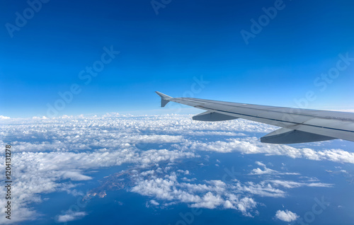 Obraz na płótnie Plane flying over clouds, view from airplane window, fluffy cloudscape and blue sky w salonie