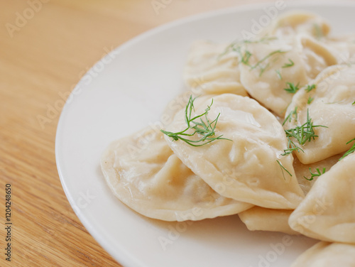 Vegan gyoza dumplings garnished with fresh dill on white plate