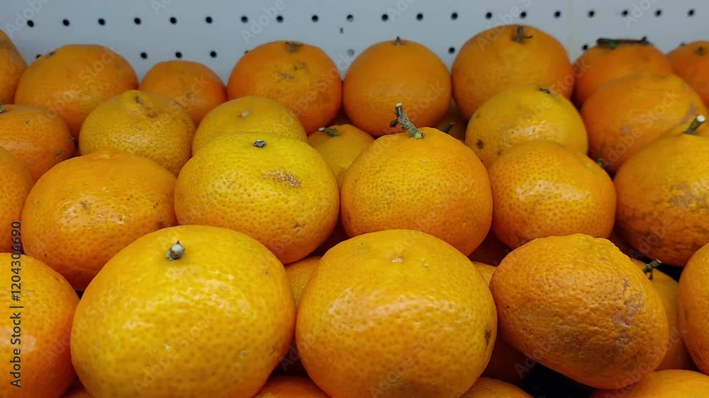 A bunch of orange oranges neatly arranged on a white perforated shelf. These oranges look fresh and eye-catching because of their bright colors and varying textures. A bunch of orange oranges neatly arranged on a white perforated shelf. These oranges look fresh and eye-catching because of their bright colors and varying textures.