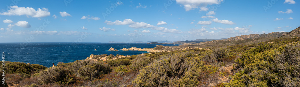 Landscape of the south-west coast of Sardinia with cliffs, blue sea, fjords and white clouds