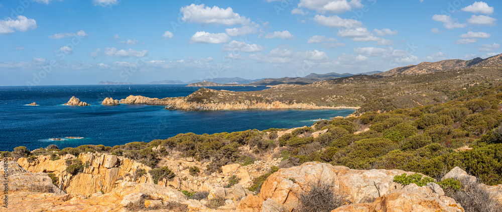 Landscape of the south-west coast of Sardinia with cliffs, blue sea, fjords and white clouds
