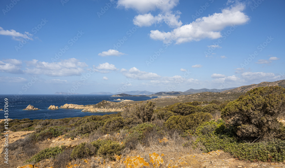 Naklejka premium Landscape of the south-west coast of Sardinia with cliffs, blue sea, fjords and white clouds