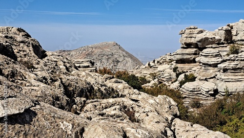 Dramatic limestone rock formations in El Torcal Natural Park, Spain. Spectacular karst landscape showcasing millions of years of erosion, creating unique layered rock formations against clear blue sky