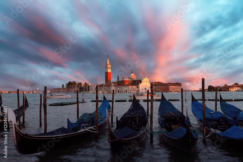 San Giorgio Maggiore church and gondolas in Venice, Italy during colorful pink sunset evening twilight. Famous landmark in Venice. photo