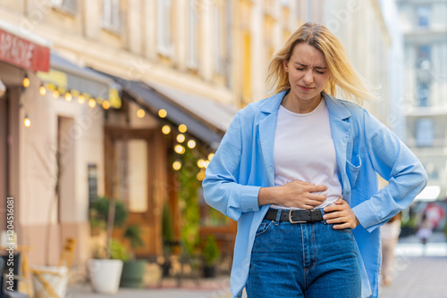 Foto Sick ill young blonde woman suffering from period cramps painful stomach ache outdoors
