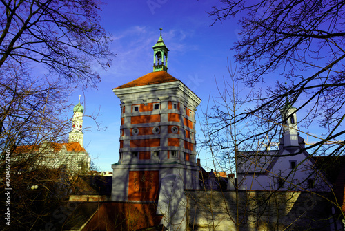 Square brick tower in a medieval town in southern Germany with bare trees in the foreground photo