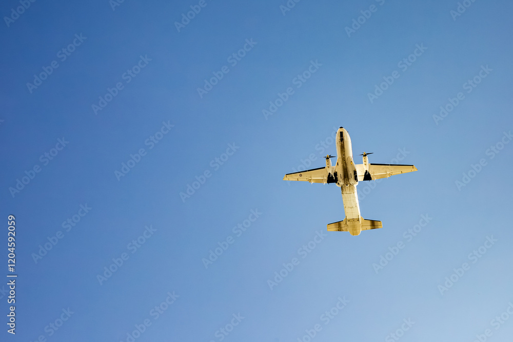 Passenger airplane soaring in clear blue sky underneath view Passenger airplane soaring in clear blue sky underneath view