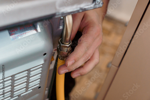Professional Technician Connecting Gas Line to Oven for Installation