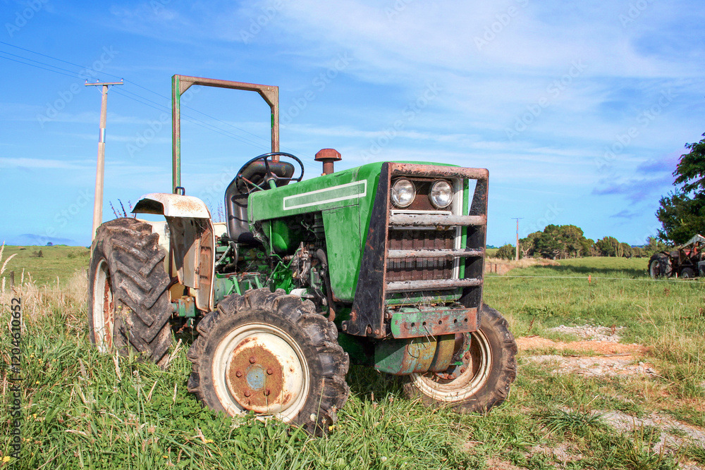 Green agricultural tractor outside on the farm in a rural area. Green agricultural tractor outside on the farm in a rural area.