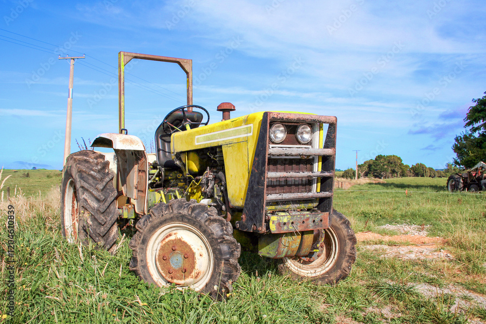 Yellow agricultural tractor outside on the farm in a rural area. Yellow agricultural tractor outside on the farm in a rural area.