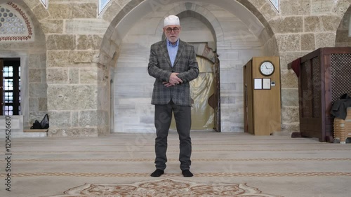 Old man praying in mosque photo