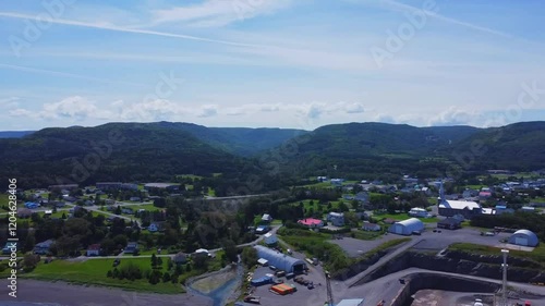 Panoramic aerial view of a small picturesque Gaspesian village surrounded by green mountains and the blue of the St. Lawrence River. Les Méchins, Quebec, Canada. photo