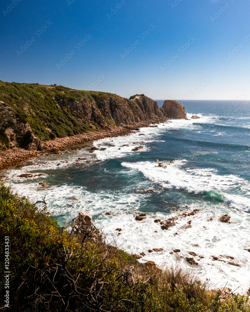 Fototapeta premium Coastal cliffs overlooking beach and ocean on a clear blue day