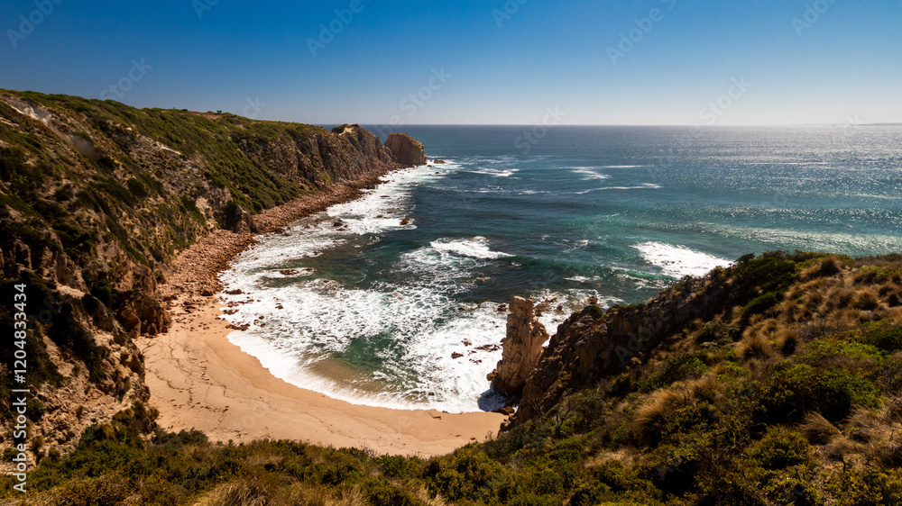 Coastal cliffs overlooking beach and ocean on a clear blue day Coastal cliffs overlooking beach and ocean on a clear blue day