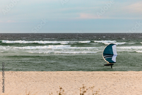 Person wing foiling using handheld inflatable wings and hydrofoil surfboard in the ocean photo