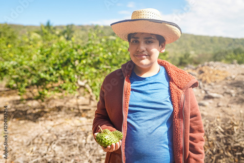 Young farmer holding soursop fruit in sustainable lemon grove photo