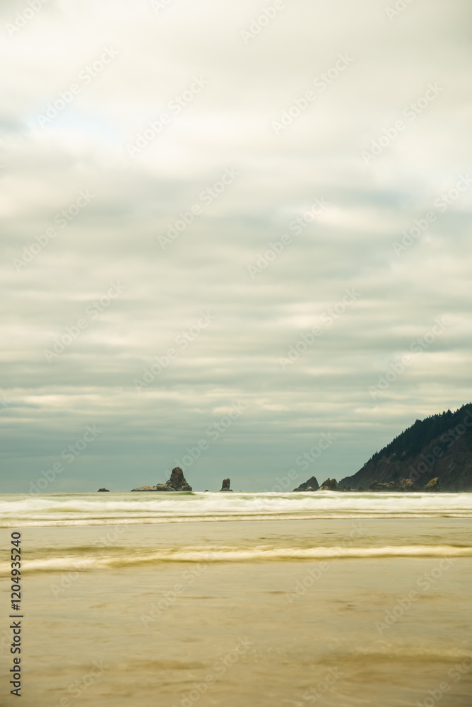 Ocean waves and distant sea stacks beneath an overcast sky. Ocean waves and distant sea stacks beneath an overcast sky.