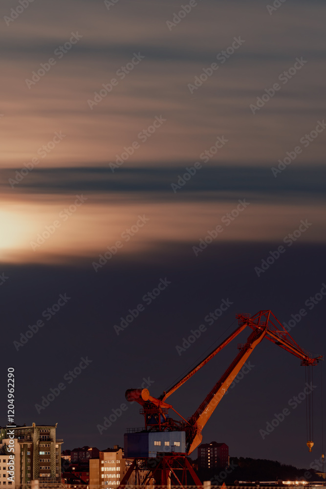 Obraz premium Harbor Crane and Urban Silhouette Beneath the Night Sky