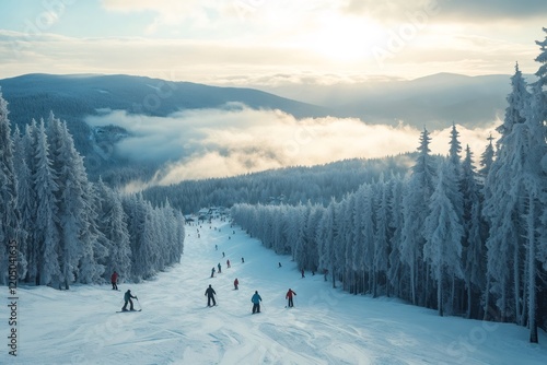 Skiers going downhill on snowy slope in scenic mountain resort at sunset
