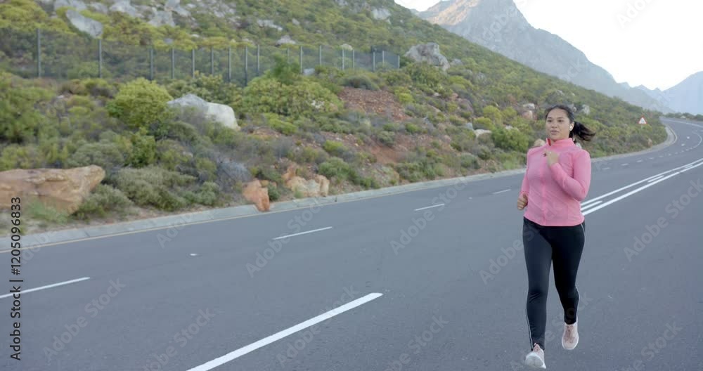 Jogging on mountain road, woman in pink jacket enjoying outdoor exercise, copy space Jogging on mountain road, woman in pink jacket enjoying outdoor exercise, copy space